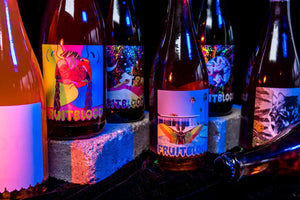bottles of fruit wine with pink lighting